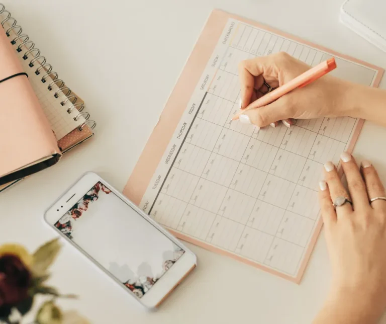 Il batching. Mani di donna che scrivono su un planner settimanale