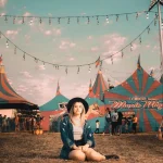 Il tuo business è come il circo: ragazza seduta davanti ai tendoni del circo